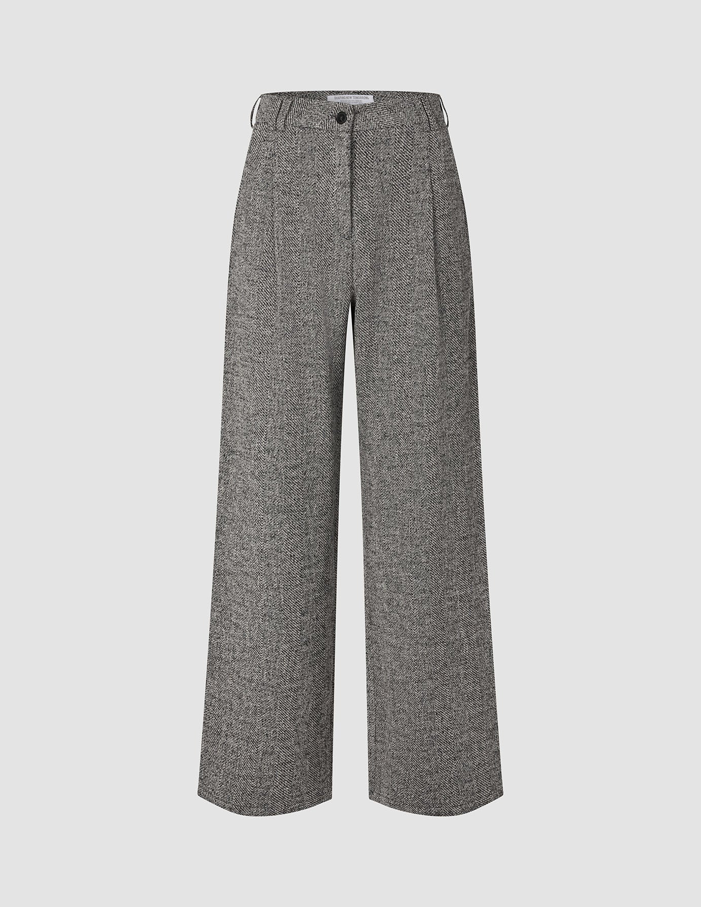 Damenhose Ashryn Wide Domino Herringbone: Eine hoch taillierte Hose mit weitem Bein aus schwarz-weißem Bouclé im Fischgrätenmuster, mit Falten auf der Vorderseite, Knopfverschluss und einem schlichten, skandinavisch inspirierten Design.